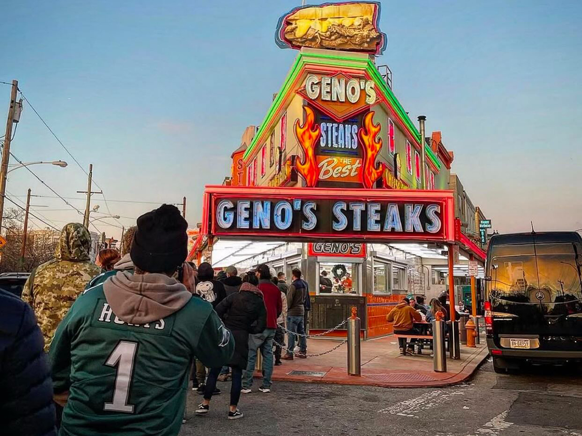 A person wearing a Philadelphia Eagles jersey waits in line at Geno's Steaks in Philadelphia.