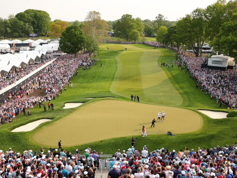 Multidões de espectadores observam um jogador de golfe profissional no green e no fairway durante o PGA Championship.