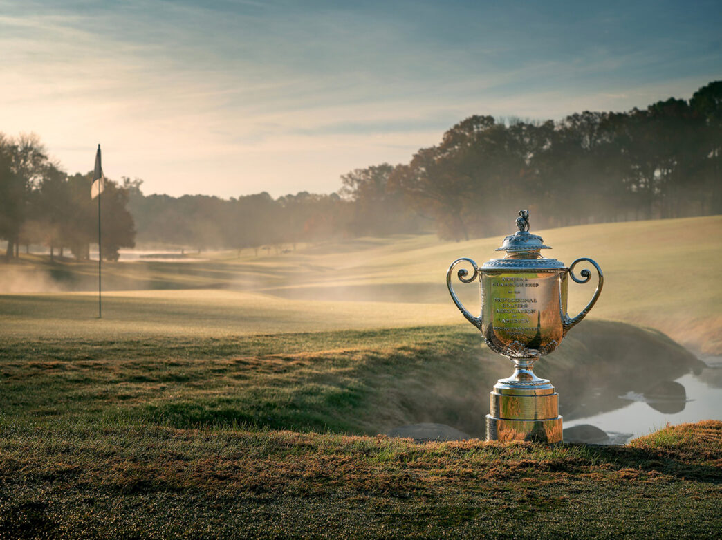 The silver Wanamaker Trophy, the trophy awarded to the winner of the PGA Championship, is displayed on a misty golf course.