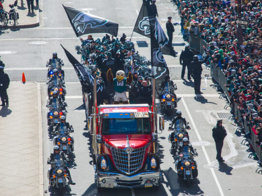 Flanké par des motos de police, un camion rouge décoré de drapeaux des Eagles transporte la mascotte de l'équipe, Swoop, les pom-pom girls et le personnel dans les rues, sous les yeux d'une foule de fans.