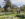 Two people walk through the Idea Garden at Longwood Gardens. The grassy garden contains blooming yellow tulips and daffodils in the flower beds.
