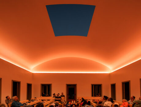 Visitors at Chestnut Hill Skyspace watch the sunset during a hole in the roof while light is projected on the ceiling around it