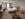 A king bed, couch with footrests and desk fill a guest room at Hilton Garden Inn Philadelphia Center City. The bed is made with white linens and the room has brown carpeting.