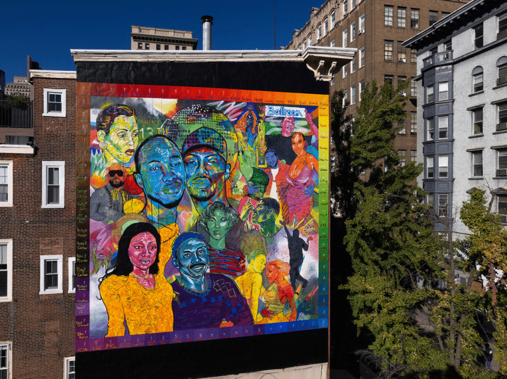 A vibrant, multicolored mural depicts the faces of historic members of Philadelphia's LGBTQ+ and Ballroom communities.