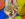 A hand holds up two halves of a cheesesteak in front of a colorful background. The roll is filled with sliced beef with melted cheese.