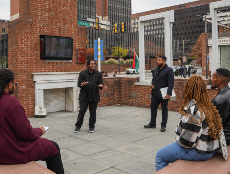 Un guía turístico de The Black Journey habla a un grupo de visitantes sentados en la Casa del Presidente de Filadelfia.