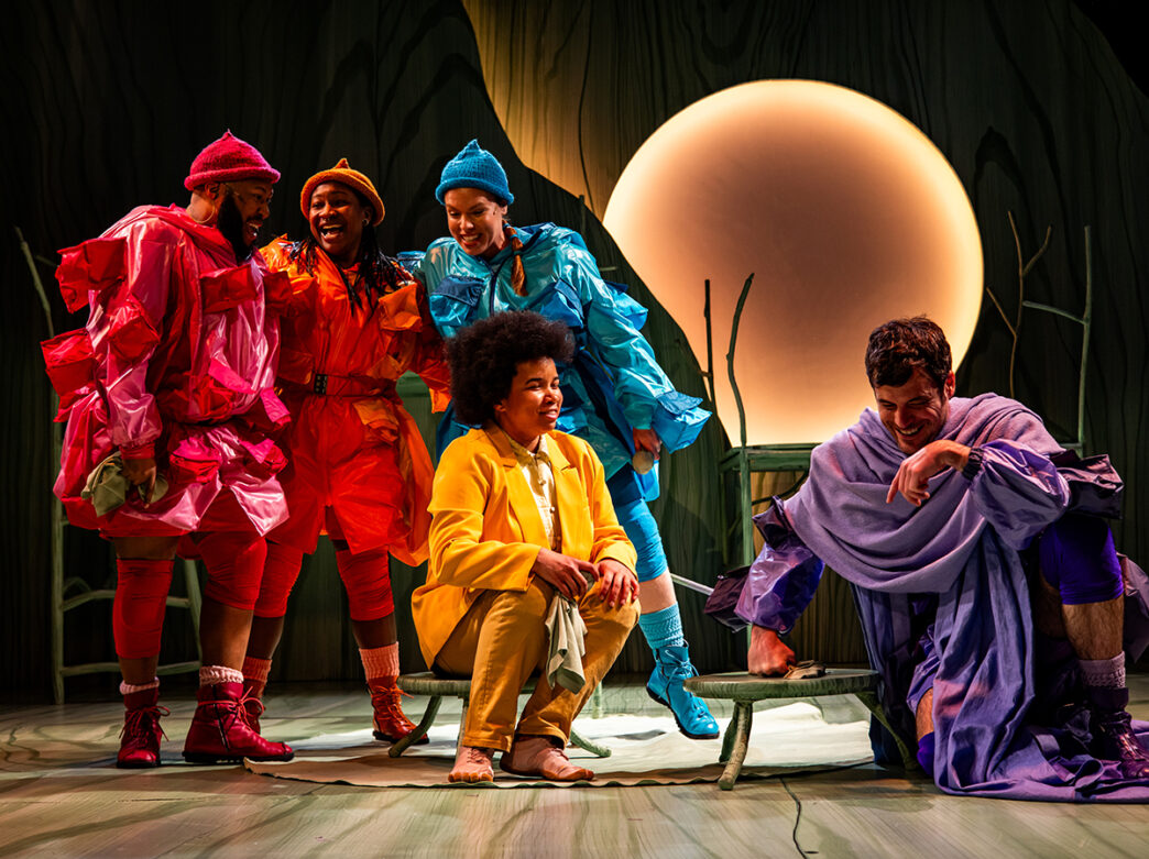 El reparto de El Hobbit actúa en el escenario de la Arden Theatre Company. Los actores llevaban trajes de colores y el escenario está ambientado con una gran luna llena brillante de fondo.