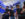 A group of players in motion-tracking suits, VR headsets and vests engage in a fully immersive virtual reality experience at Sandbox VR, surrounded by futuristic tech.