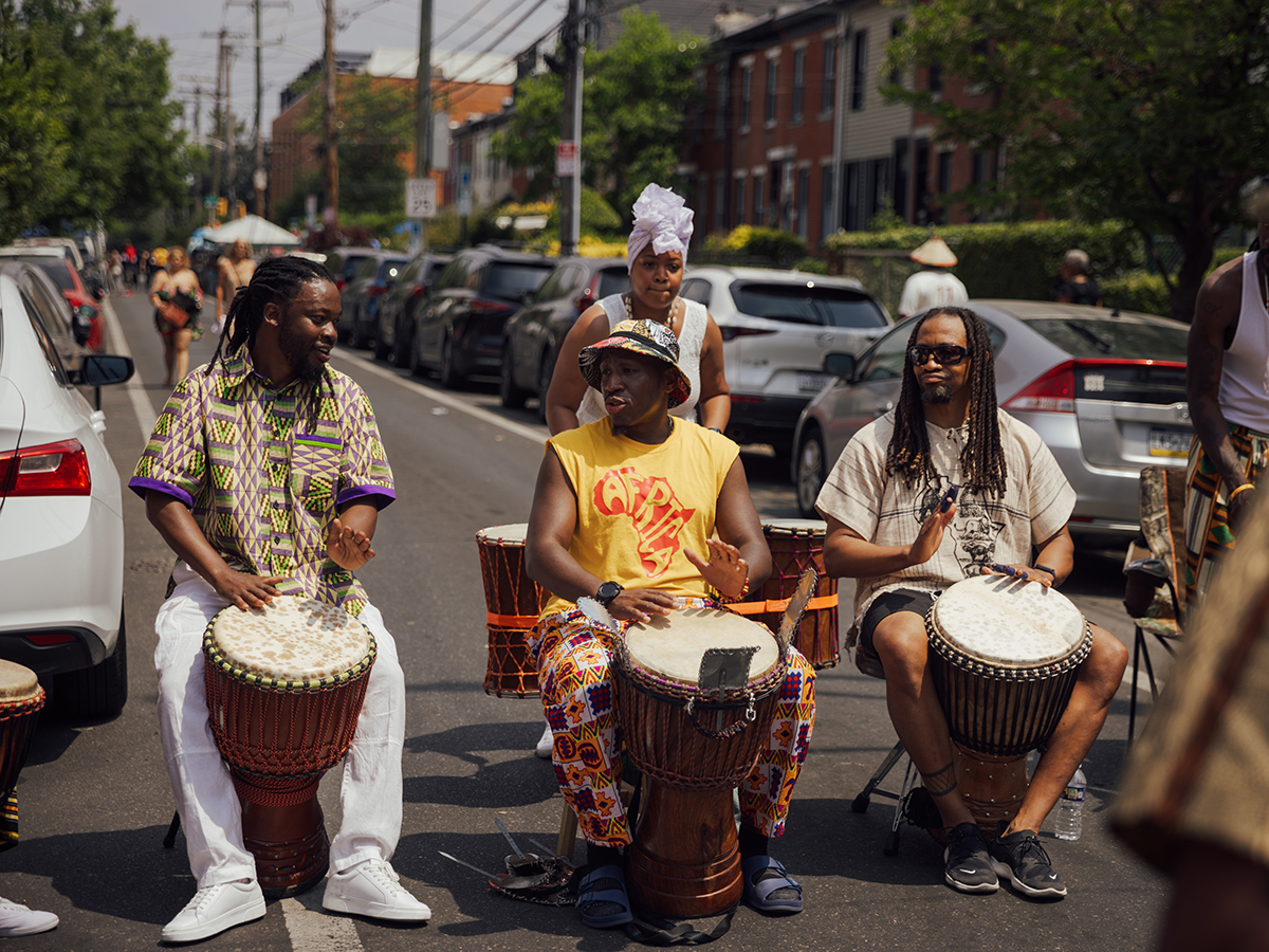 Three men play African drums on a car free city street during the ODUNDE Festival.