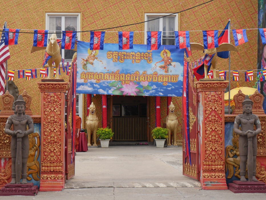El exterior del templo Preah Buddha Rangsey de Filadelfia, con una puerta de entrada roja y naranja decorada con estatuas de bronce y oro.
