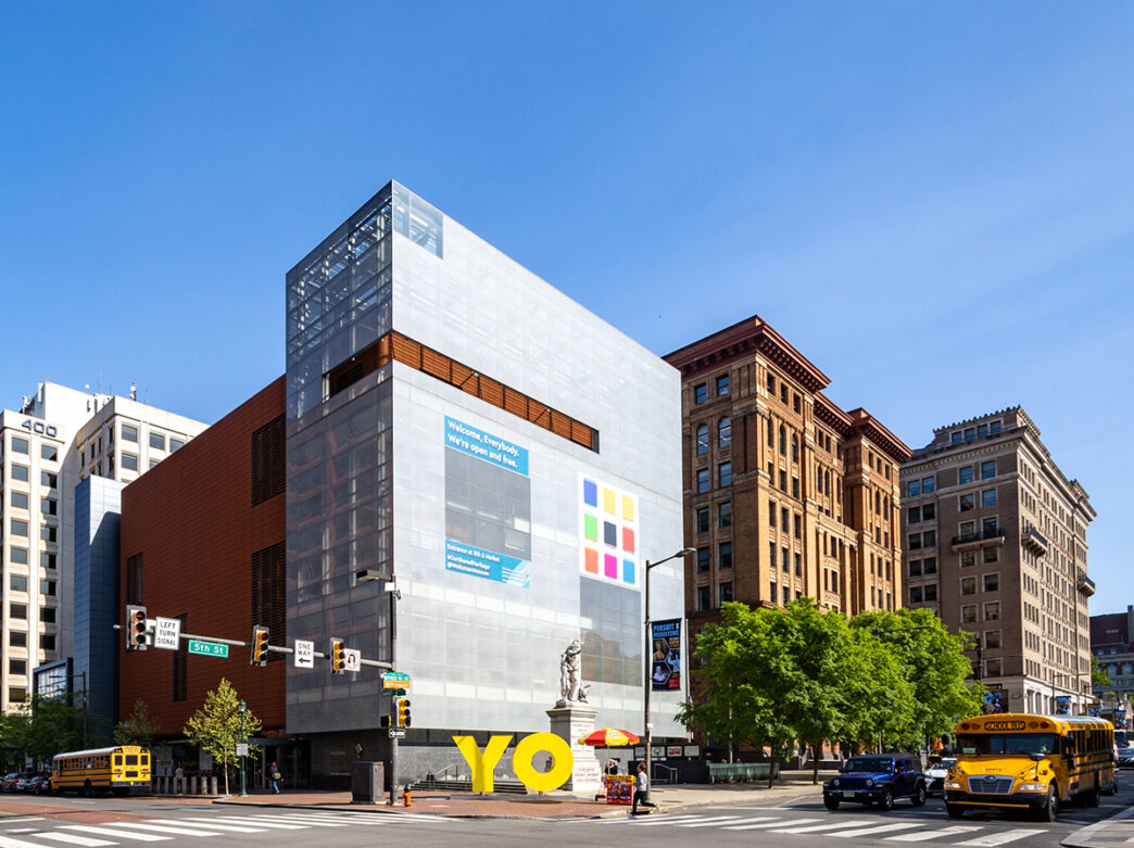 Een knalgele sculptuur van de letters Y en O staan buiten een glazen gebouw, de Weitzman National Museum of American Jewish History.