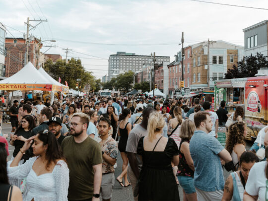 Una gran multitud se reúne en el 2nd Street Festival en Northern Liberties, con puestos de comida y carpas a lo largo de una calle cerrada al tráfico.