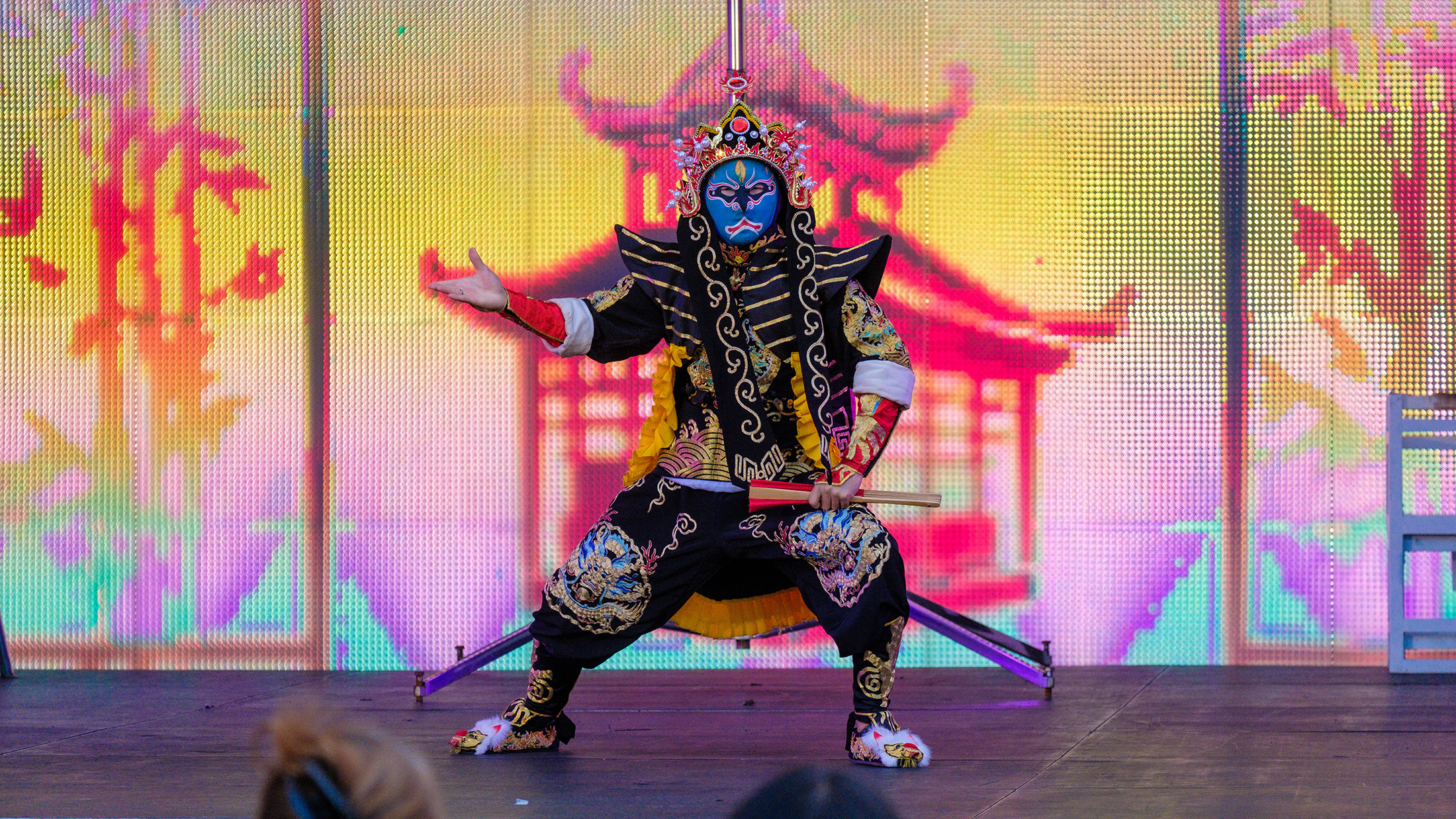 A performer in ornate traditional costume does a Chinese face-changing performance on stage during the Chinese Lantern Festival.