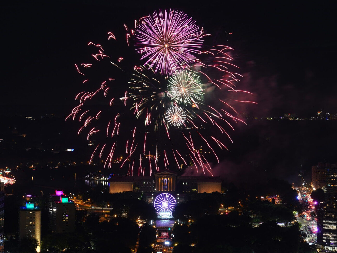 Un resplandeciente espectáculo de fuegos artificiales estalla sobre la Philadelphia Museum of Art y Benjamin Franklin Parkway en un cielo nocturno.