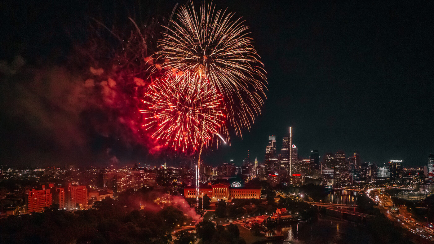Large red and gold fireworks erupt in a dark sky over the Philadelphia Museum of Art in Philadelphia.