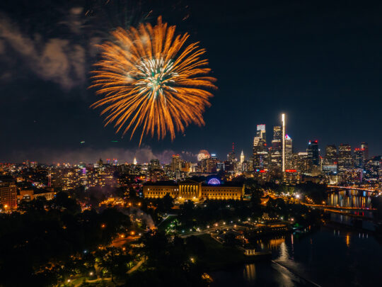A large orange and gold firework erupts over the Philadelphia Museum of Art in Philadelphia.