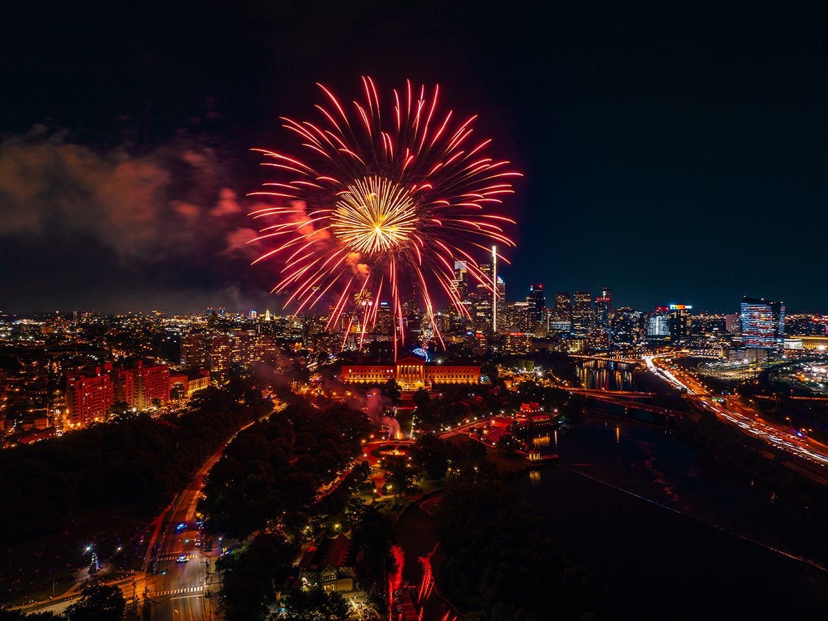 A large red and yellow firework erupts over the Philadelphia Museum of Art in Philadelphia.