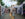 A couple walks hand-in-hand down a street lined with white vendor tents at the bustling Manayunk Arts Festival.