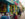 Diners enjoy food and drinks at colorful outdoor tables in front of the bright blue and yellow facade of Taqueria Amor in Manayunk.