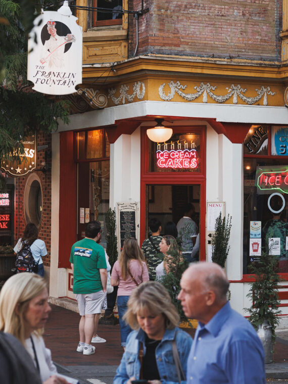 People walk and gather outside Franklin Fountain, a charming old-school ice cream shop in Old City.