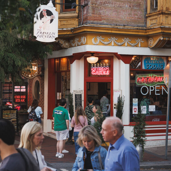 People walk and gather outside Franklin Fountain, a charming old-school ice cream shop in Old City.