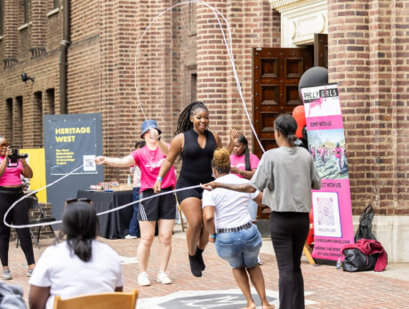 A group of women jump rope together during a Juneteenth event outside the Penn Museum. Onlookers cheer and capture the fun on camera.