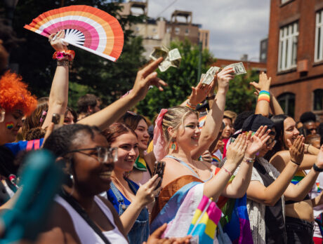 People wearing rainbow outfits and accessories clap and cheer during the Pride March and Festival in Philadelphia.