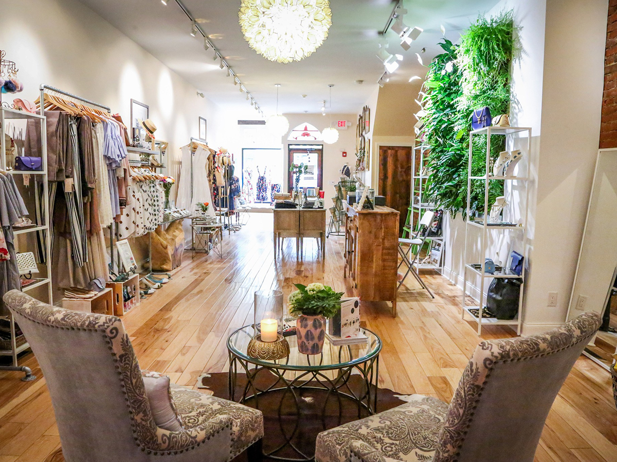 The airy and elegant interior of LILA Philadelphia, a boutique in Manayunk, displays clothing and accessories.