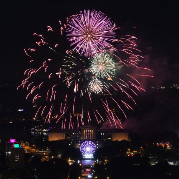 Un feu d'artifice incandescent explose au-dessus du Philadelphia Museum of Art et du Benjamin Franklin Parkway dans un ciel nocturne.