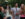 A group of smiling young adults holding cups of beer interact with a zookeeper holding a lizard at the Philadelphia Zoo's Ale Festival.