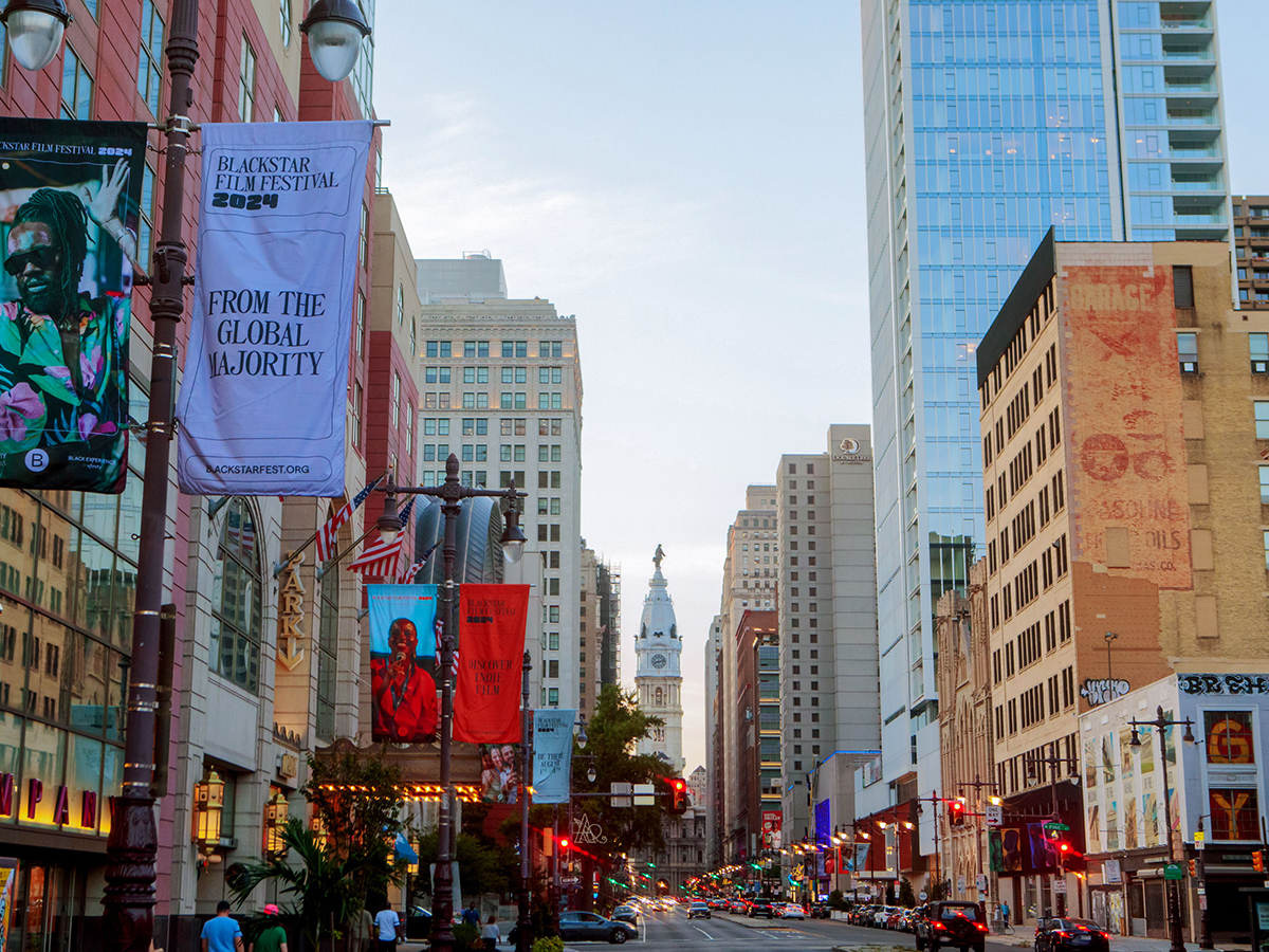 Des bannières annonçant le BlackStar Film Festival sont accrochées aux lampadaires qui bordent Broad Street, avec City Hall visible au loin.
