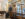 Two people with suitcases walk through glass doors into the lobby at Canopy by Hilton Philadelphia.