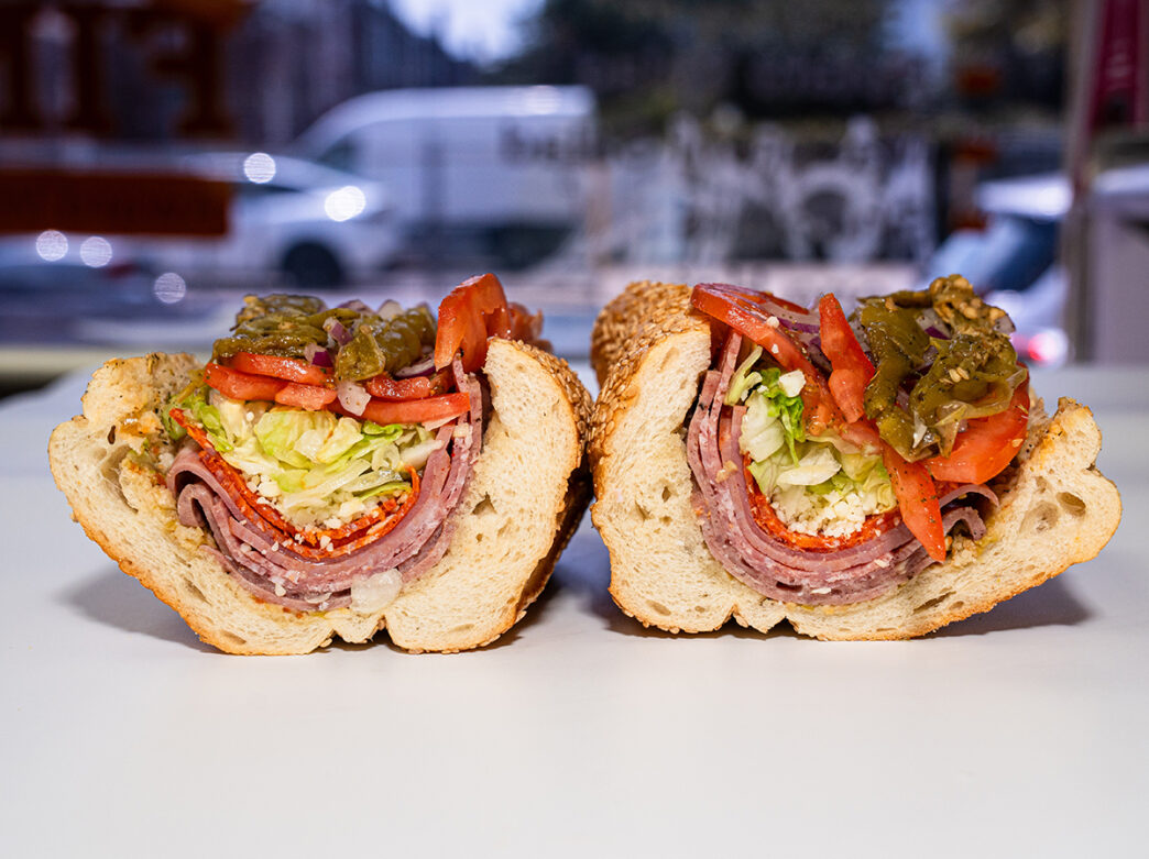 A hoagie cut in half and stuffed with layers of salami, pepperoni, lettuce, tomato and long-hot peppers at Fink's Hoagies.
