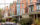 A row of brick Victorian homes with colorful and ornate accents line a residential street in West Philadelphia.