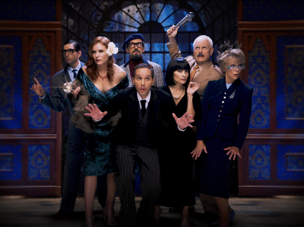 Seven actors in costumes pose dramatically in a theatrical scene inspired by the board game Clue.
