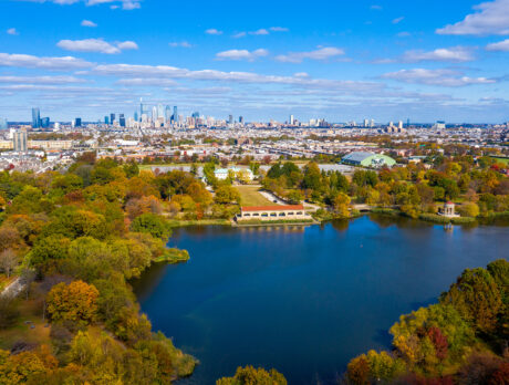 An aerial view of FDR Park in South Philadelphia, with tree-lined streets, a lake and the Center City skyline in the distance.