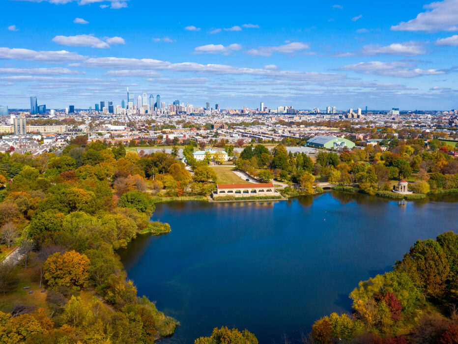 An aerial view of FDR Park in South Philadelphia, with tree-lined streets, a lake and the Center City skyline in the distance.