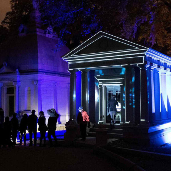 Visitors gather outside an illuminated mausoleum at Laurel Hill Cemetery during the Soul Crawl nighttime tour.