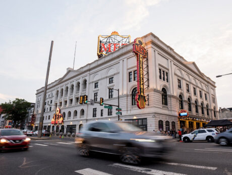 Exterior of The Met Philadelphia, a marquee glows and cars drive by
