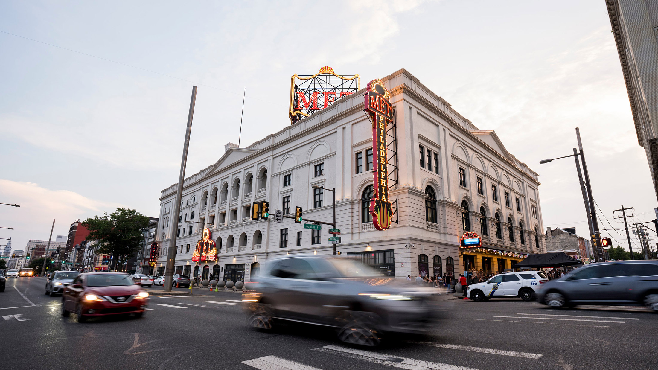 Exterior of The Met Philadelphia, a marquee glows and cars drive by