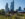 A could walks along a flower-lined path at Calder Gardens, with the city skyline in the background.