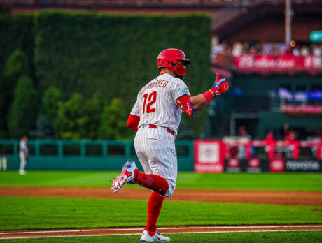 Kyle Schwarber gives his teammates a thumbs up gesture as he jogs toward first base during a game.