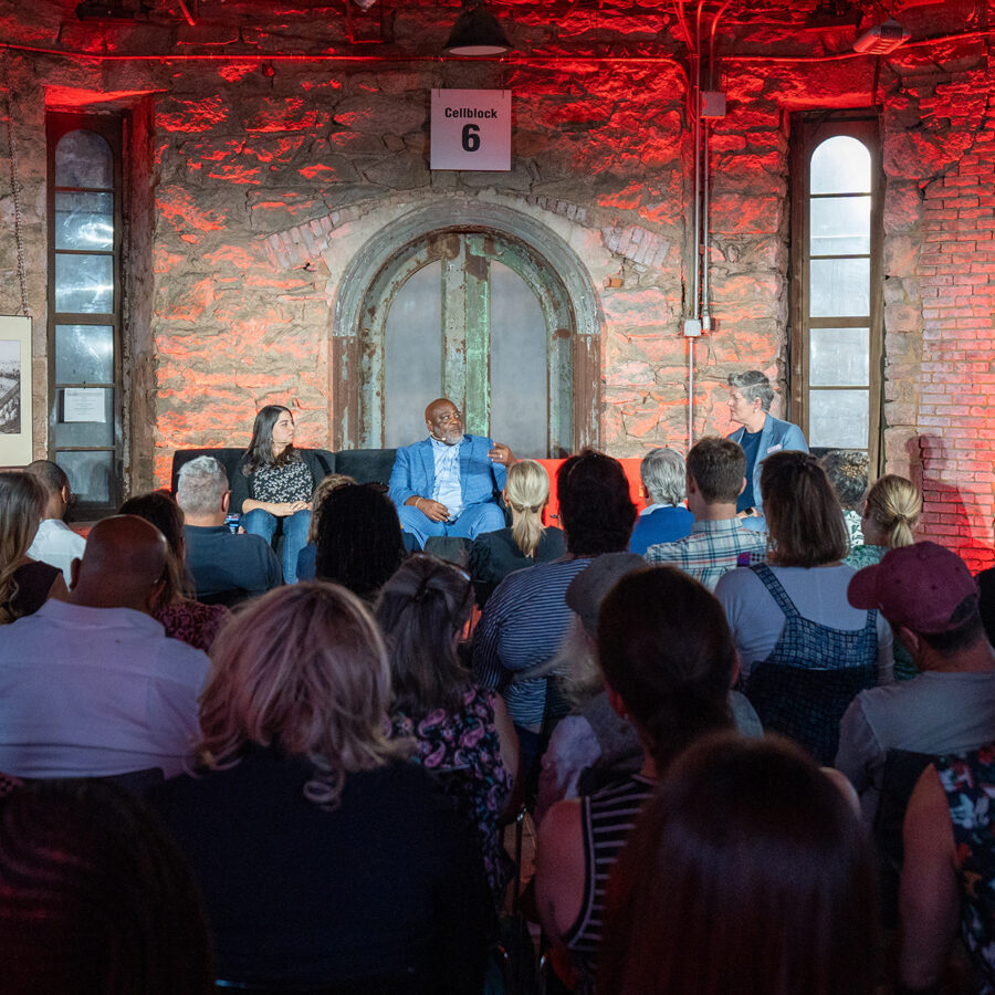 Three people talk on a stage at Eastern State Penitentiary in Philadelphia during the TED Democracy Fireside Chat in 2024