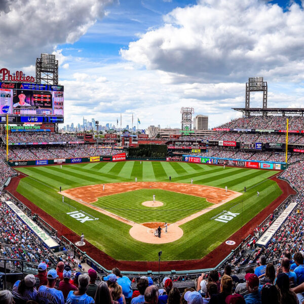 Le Citizens Bank Park bondé lors d'un match des Phillies de Philadelphie, avec les fans remplissant les gradins et la silhouette de Philadelphie en arrière-plan.