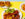 A colorful sampler plate of Puerto Rican food with yellow rice, skewered meat, fried plantains and a salad is displayed on a yellow tabletop alongside smaller dishes in the background.