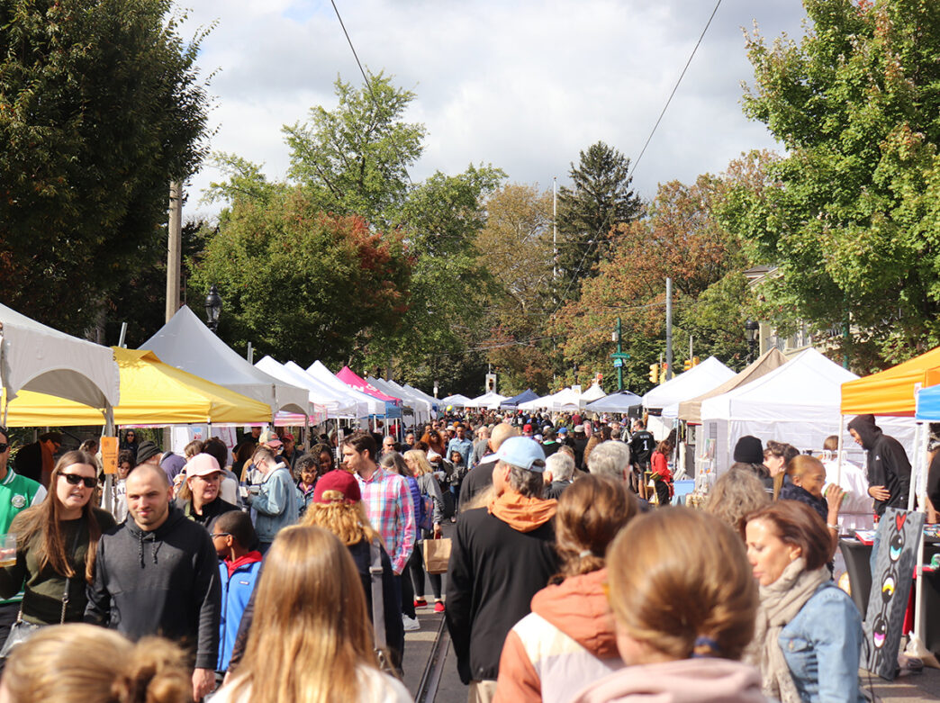 Crowds walk along car-free Germantown Avenue, lined with colorful vendor tends during the Chestnut Hill Fall for the Arts Festival.