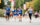 A group of young runners wearing blue shirts that read, "Students Run Philly Style," compete in a race on the Benjamin Franklin Parkway.