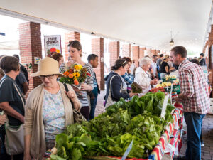 Winkelend publiek bekijkt verse producten en bloemen op de Headhouse Farmers Market.