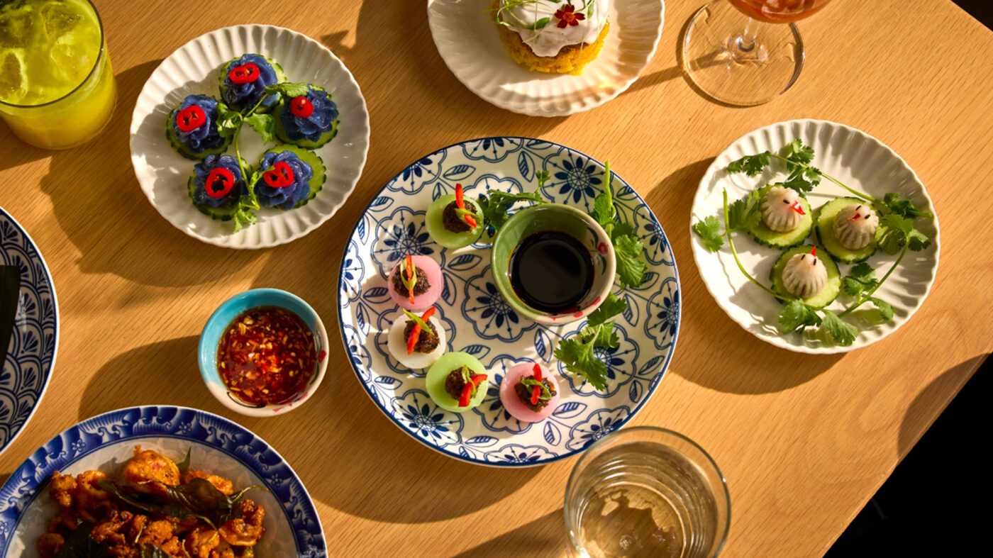 Dishes and plates featuring dumplings and other selections arranged artfully on a wooden tabletop at Kalaya.