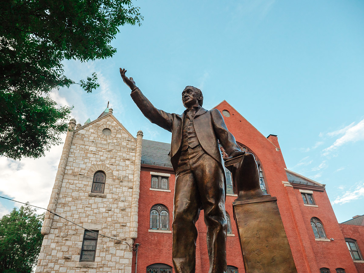 A bronze statue of the founder of Mother Bethel A.M.E. Church, Reverend Richard Allen, stands with one hand raised in front of the historic church.